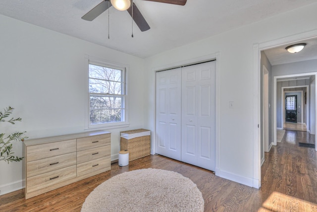 bedroom with a closet, ceiling fan, and dark wood-type flooring