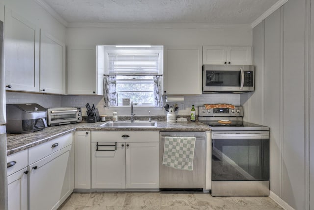 kitchen with appliances with stainless steel finishes, backsplash, crown molding, sink, and white cabinets