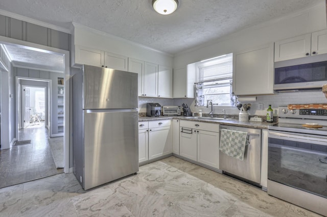 kitchen with sink, a textured ceiling, decorative backsplash, white cabinets, and appliances with stainless steel finishes