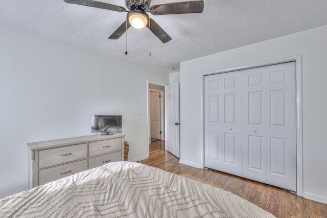 bedroom featuring ceiling fan, a closet, a textured ceiling, and light hardwood / wood-style flooring