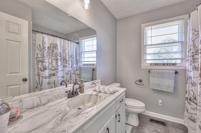 bathroom featuring tile patterned flooring, vanity, toilet, and plenty of natural light