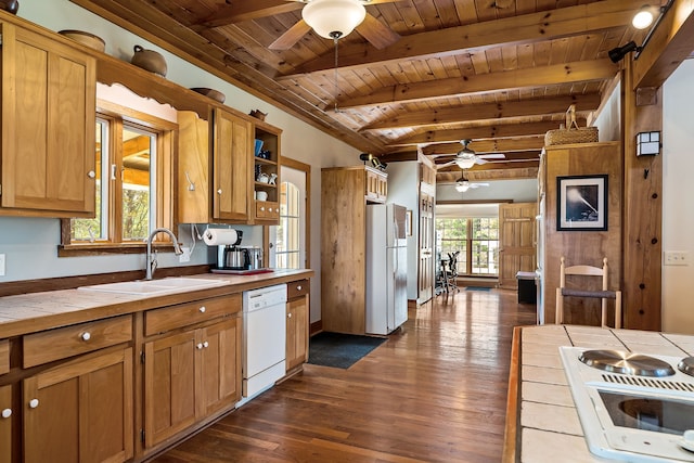 kitchen featuring white appliances, dark wood-type flooring, sink, beamed ceiling, and tile counters