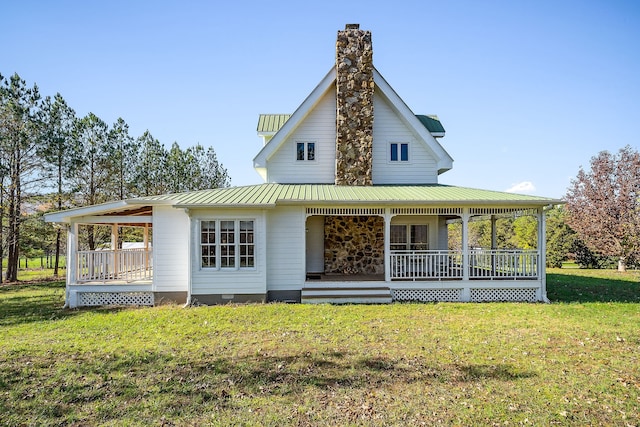 rear view of property featuring a lawn and covered porch