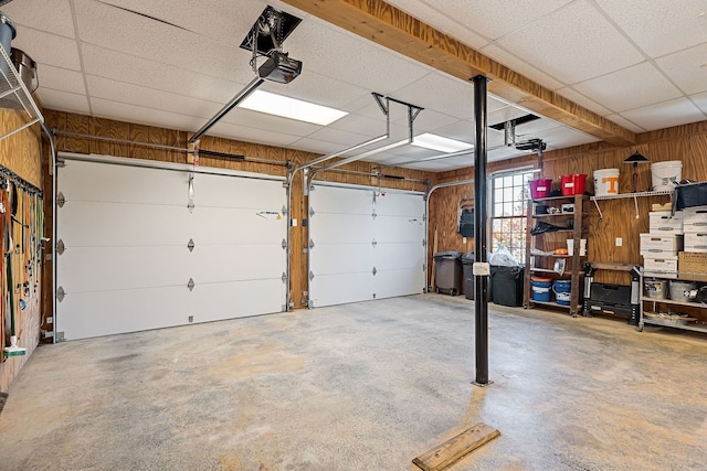 garage with wood walls and a garage door opener