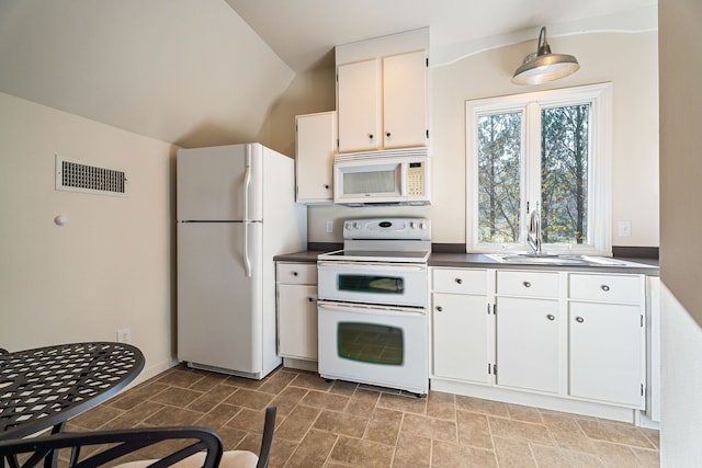 kitchen with vaulted ceiling, sink, white cabinets, and white appliances