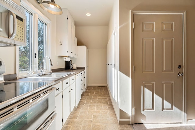 kitchen featuring white cabinets, white appliances, and sink