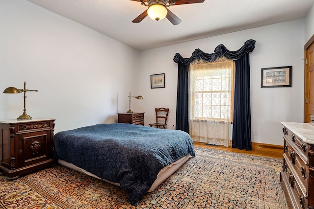 bedroom with ceiling fan and dark wood-type flooring