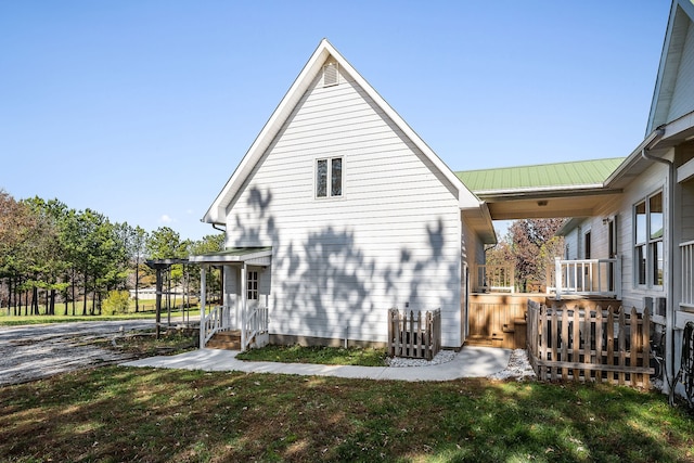 view of side of home with a porch and a yard