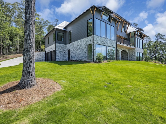 exterior space with a balcony, a garage, and a lawn