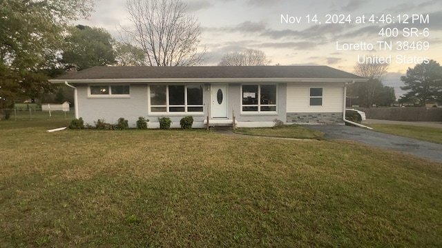 single story home with a lawn