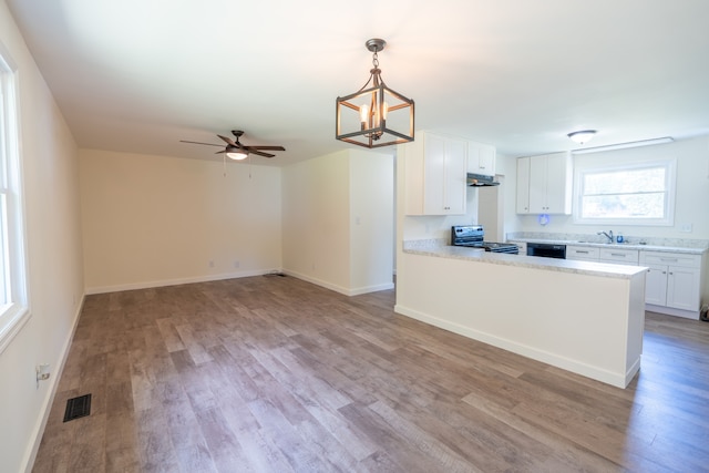 kitchen with stainless steel electric stove, white cabinetry, kitchen peninsula, and light hardwood / wood-style flooring