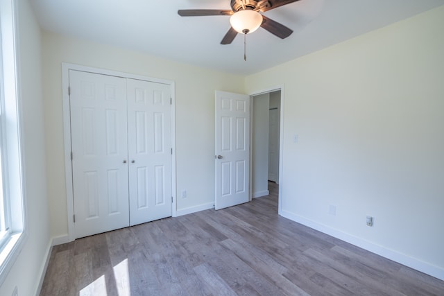 unfurnished bedroom featuring a closet, ceiling fan, and light hardwood / wood-style flooring