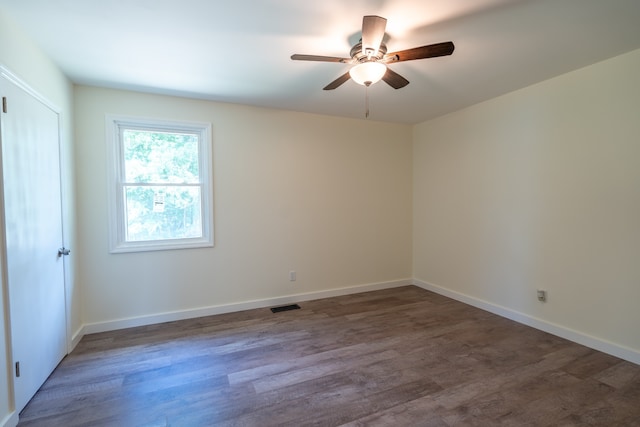 spare room featuring ceiling fan and dark wood-type flooring