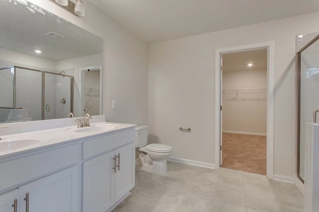 bathroom with vanity, a shower with shower door, and toilet