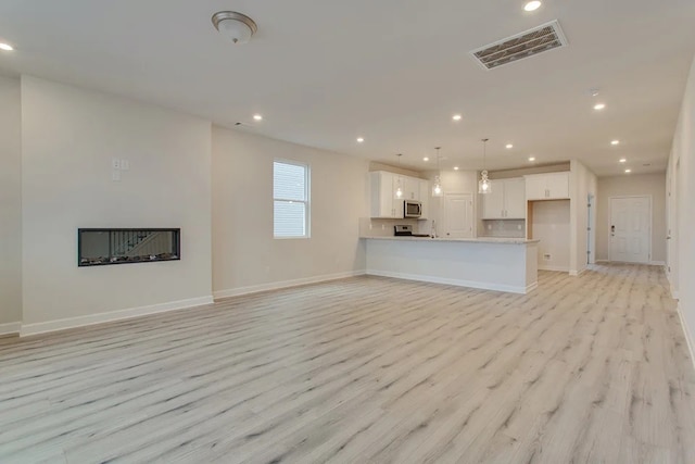 unfurnished living room with light hardwood / wood-style flooring