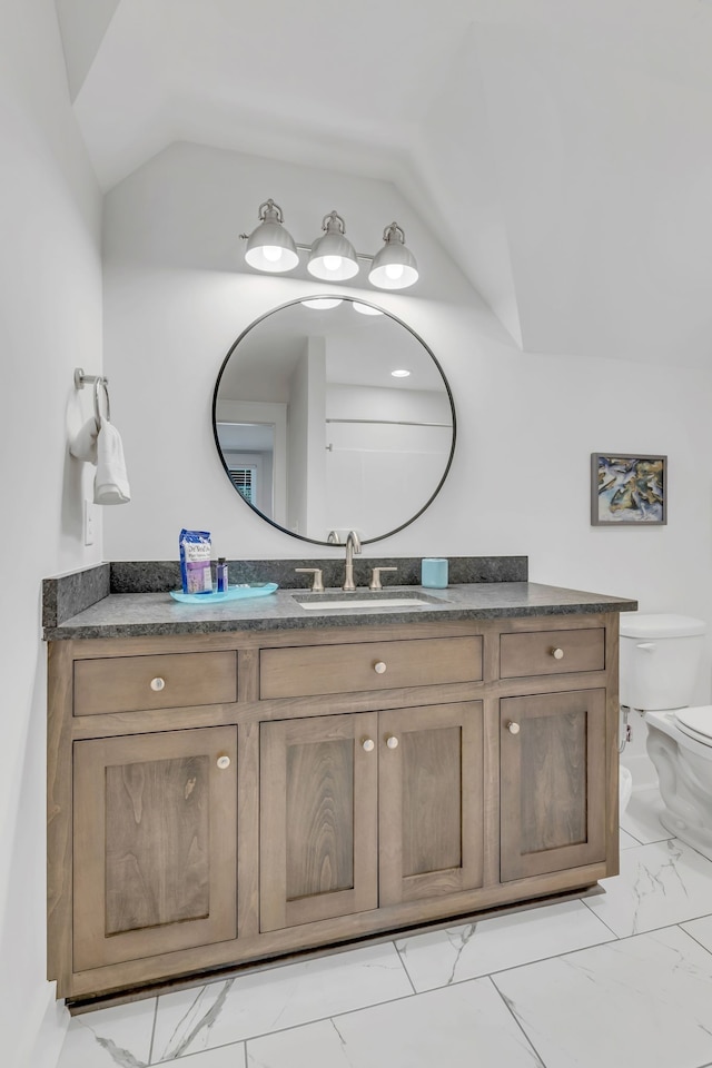 bathroom with vanity, toilet, and lofted ceiling