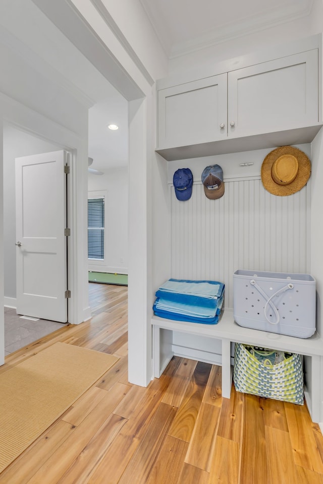 mudroom with ornamental molding, a baseboard radiator, and light wood-type flooring