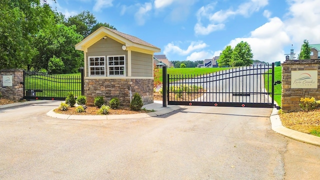 view of gate with a lawn