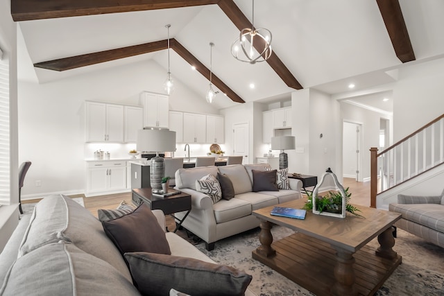 living room with beamed ceiling, light wood-type flooring, high vaulted ceiling, and a chandelier