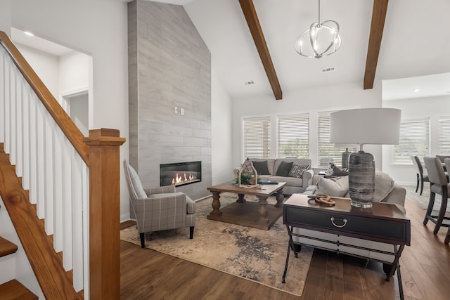 living room featuring vaulted ceiling with beams, hardwood / wood-style floors, and a fireplace