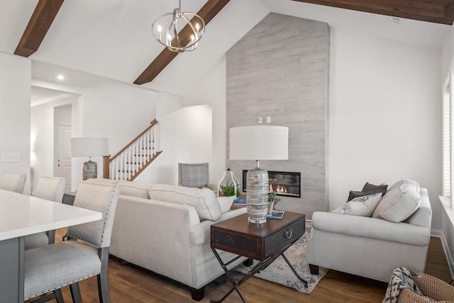 living room with a tile fireplace, wood-type flooring, high vaulted ceiling, an inviting chandelier, and beamed ceiling