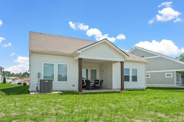 rear view of house featuring a yard, cooling unit, and a patio area