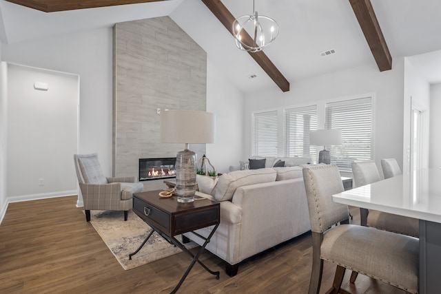 living room with an inviting chandelier, beam ceiling, dark hardwood / wood-style flooring, and a tiled fireplace