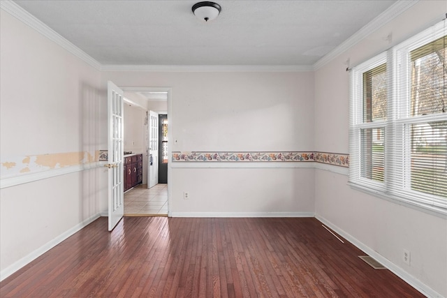 empty room with hardwood / wood-style flooring and ornamental molding