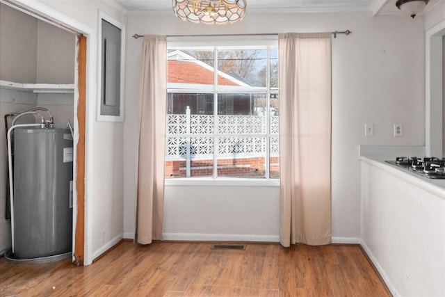 doorway featuring water heater, ornamental molding, light hardwood / wood-style floors, and an inviting chandelier