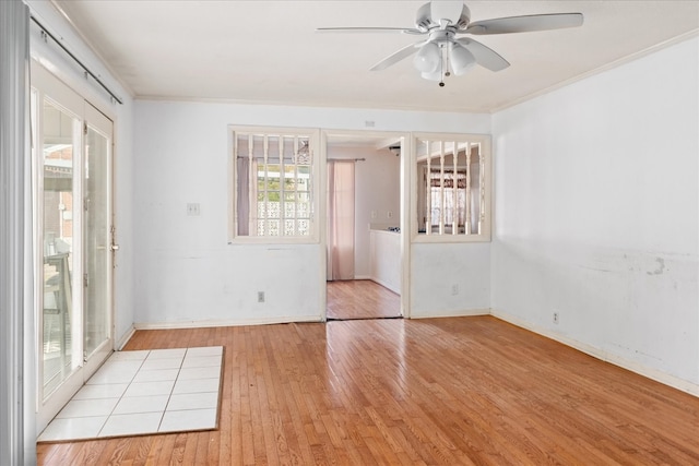 empty room with ceiling fan, french doors, ornamental molding, and light wood-type flooring