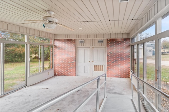 unfurnished sunroom featuring ceiling fan