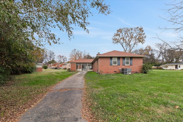 view of front facade with central air condition unit and a front lawn