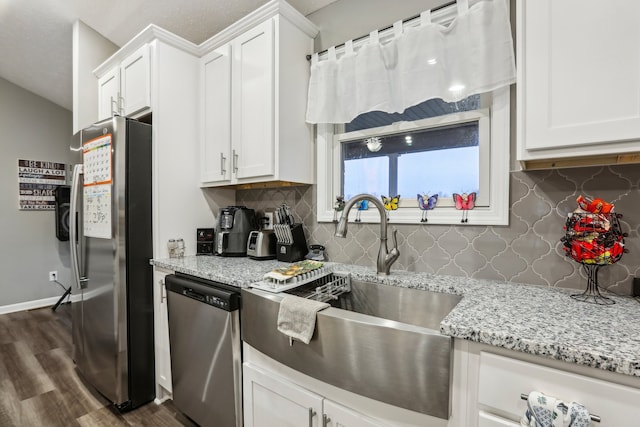 kitchen featuring backsplash, white cabinets, sink, appliances with stainless steel finishes, and dark hardwood / wood-style flooring