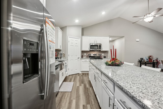 kitchen with hardwood / wood-style floors, white cabinetry, and stainless steel appliances