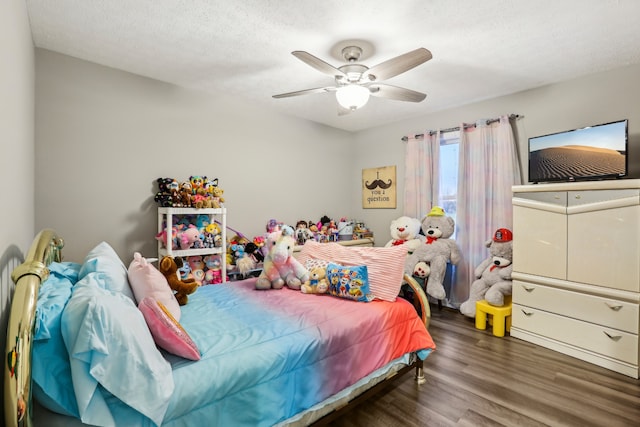 bedroom with ceiling fan, dark wood-type flooring, and a textured ceiling