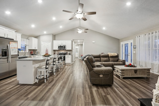 living room featuring ceiling fan, lofted ceiling, and dark wood-type flooring