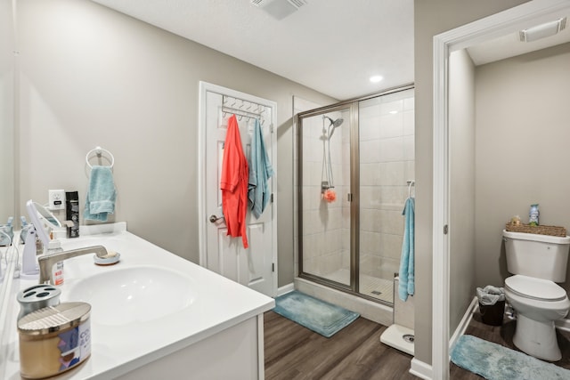 bathroom featuring walk in shower, toilet, vanity, and hardwood / wood-style flooring