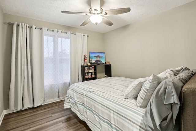 bedroom featuring ceiling fan, hardwood / wood-style floors, and a textured ceiling