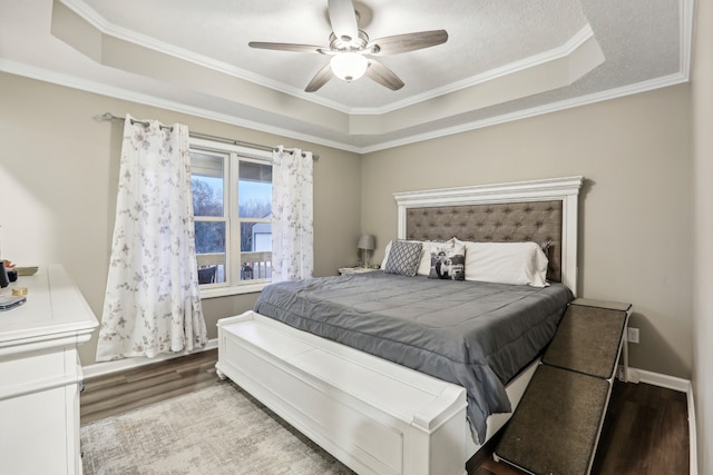 bedroom with a raised ceiling, ceiling fan, light hardwood / wood-style flooring, and ornamental molding