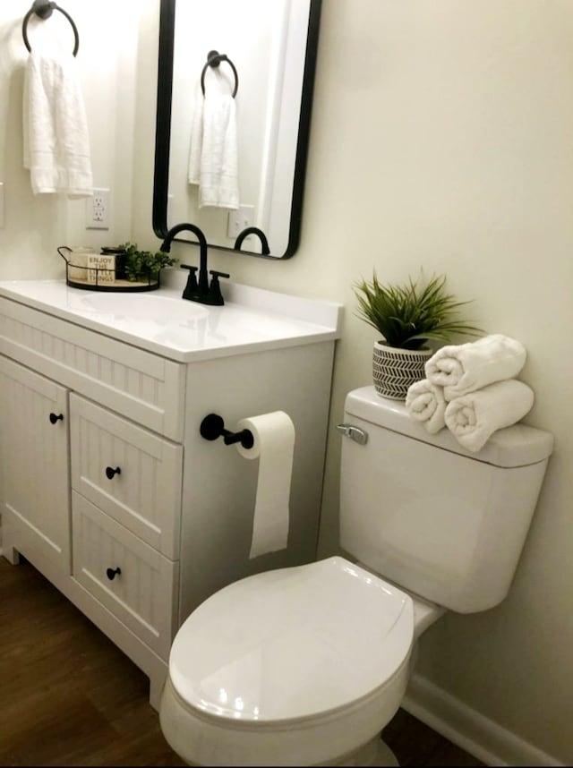 bathroom with vanity, toilet, and wood-type flooring