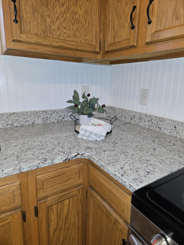 room details featuring light stone countertops and stainless steel range with electric stovetop