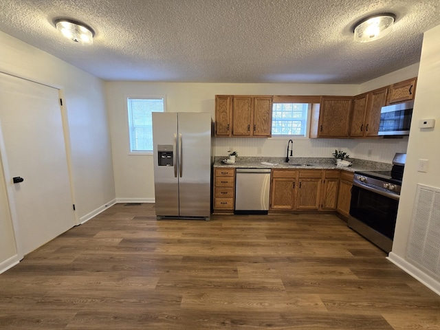 kitchen featuring a textured ceiling, stainless steel appliances, dark hardwood / wood-style floors, and sink