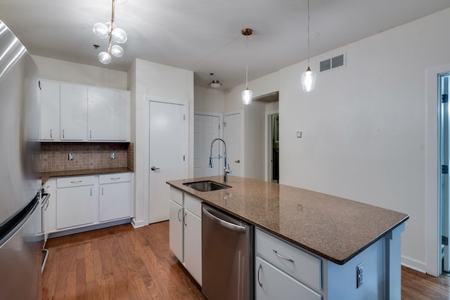 kitchen featuring white cabinetry, sink, pendant lighting, a center island with sink, and appliances with stainless steel finishes