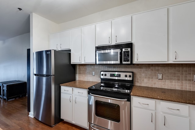 kitchen featuring dark hardwood / wood-style floors, dark stone countertops, white cabinetry, and appliances with stainless steel finishes