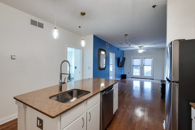 kitchen featuring appliances with stainless steel finishes, ceiling fan, sink, a center island with sink, and white cabinets