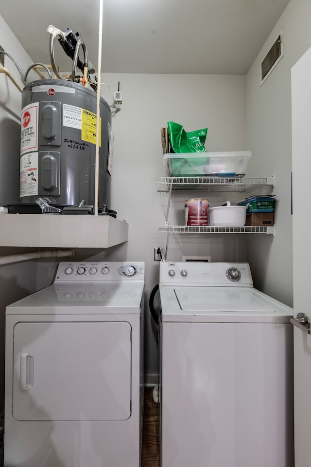 laundry room with water heater and washer and clothes dryer