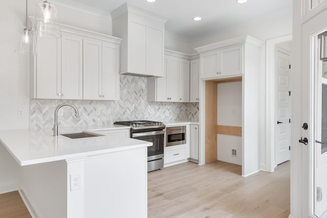 kitchen featuring white cabinets, pendant lighting, sink, and stainless steel appliances