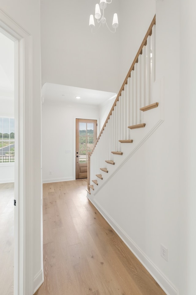 entryway featuring an inviting chandelier and light hardwood / wood-style flooring