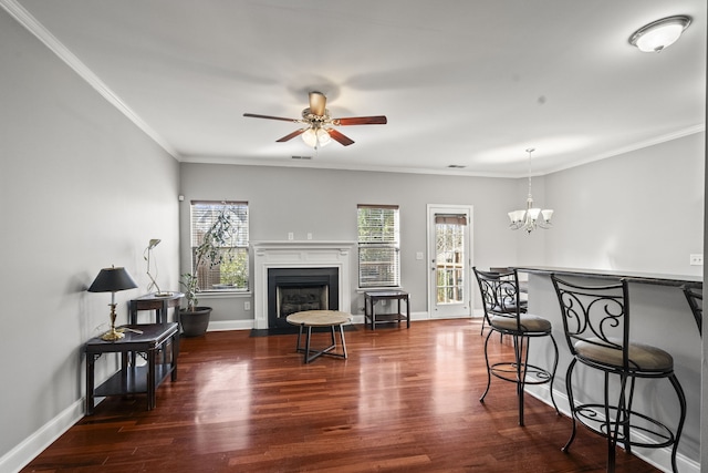 living room with ceiling fan with notable chandelier, dark hardwood / wood-style floors, and ornamental molding