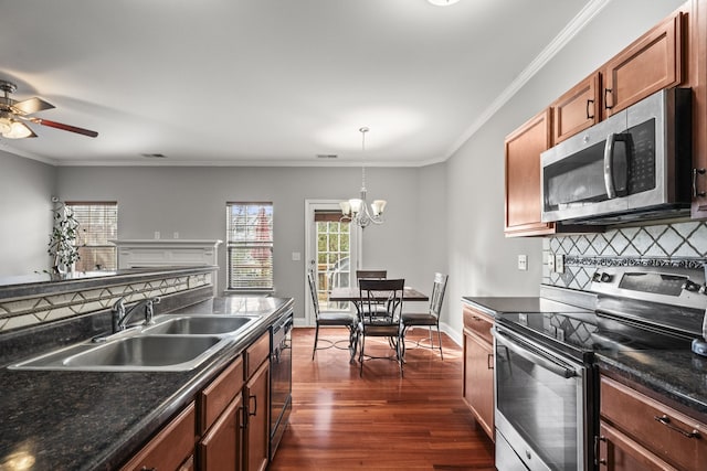 kitchen featuring backsplash, sink, dark hardwood / wood-style floors, decorative light fixtures, and stainless steel appliances